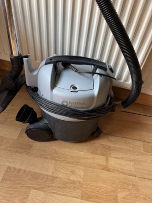 un aspirateur posé par terre à côté d'un radiateur