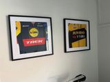 two framed posters on the wall above a bike