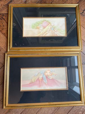two framed paintings of a woman and a child on a wooden floor