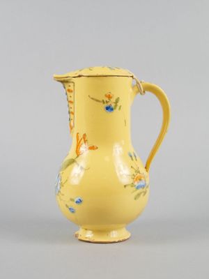 a small yellow vase with a floral design on it