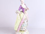 une image représentant une figurine de femme vêtue d'une robe violette