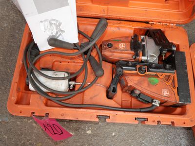 une mallette orange posée par terre, contenant des outils