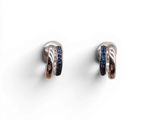 une paire de boucles d'oreilles en argent et saphir bleu sur fond blanc