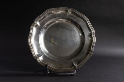 une assiette en argent posée sur un socle, sur fond noir