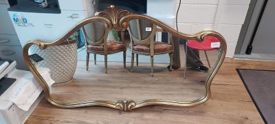 a mirror that is sitting on the floor next to a chair