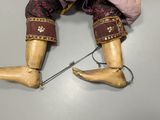 a doll that is sitting on a table with a pair of shoes