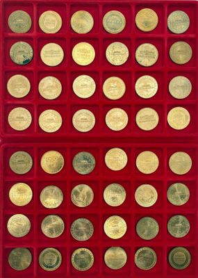 un gros plan sur une boîte rouge contenant de nombreuses pièces d'or