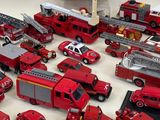 a lot of toy fire trucks and trucks on the table
