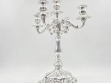 a silver plated candelab with four candles on a stand