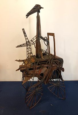 a metal sculpture of a bird sitting on top of a cart