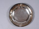 a silver plate on a white table with a white background