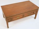 a small wooden table with two drawers on it