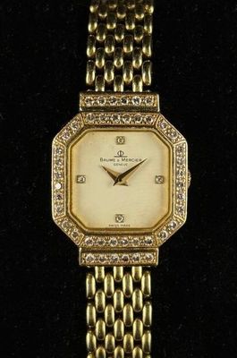 un gros plan d'une montre en or sertie de diamants