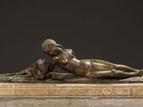 bronze sculpture of a woman laying on a marble base