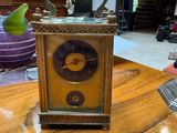a small clock sitting on a wooden table in a room