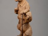 statue of a rat with a cane on a wooden block