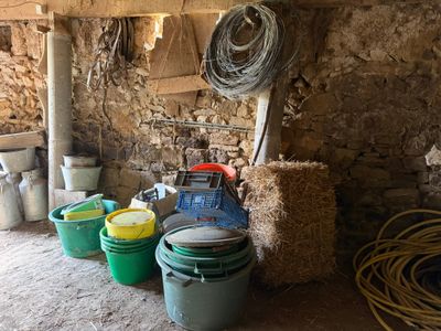 de nombreux seaux d'eau dans une pièce aux murs de pierre