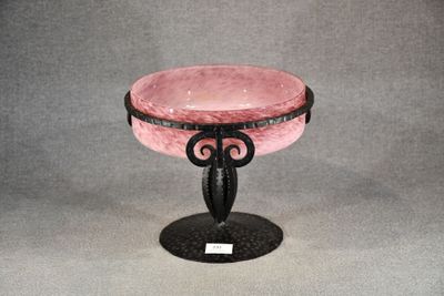 un bol en verre rose posé sur un socle noir, sur un fond gris