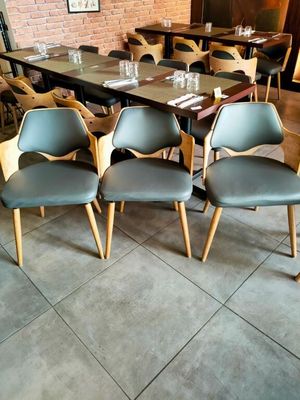 des tables et des chaises dans un restaurant, avec un mur en briques en arrière-plan