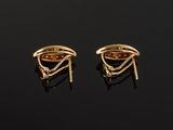 a pair of gold earrings on a black surface