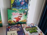 Plusieurs jeux de société pour enfants sont posés sur une étagère dans un coin de la pièce