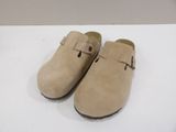 pair of beige sued clogs with buckles on them