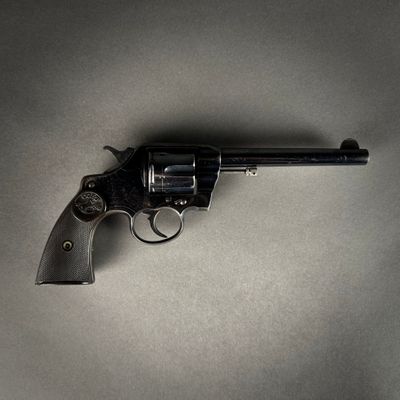 un pistolet posé sur une table, sur fond gris