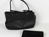 un sac à main et un portefeuille noirs posés sur une surface blanche, sur fond blanc