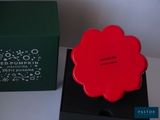 a red flower in a black box next to a green box