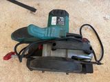 a corded sander on the floor next to a pair of scissors