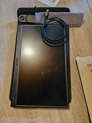 une tablette posée sur une table, avec un chargeur dessus