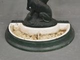 a statue of a dog sitting on top of a bowl