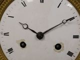 a gold clock with roman numerals on the face