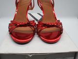 une paire de sandales rouges à talons hauts dans une boîte