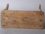 a wooden box with writing on it on a gray surface