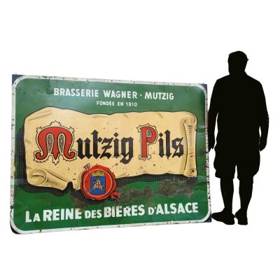 a man standing in front of a sign that says mutzen pils