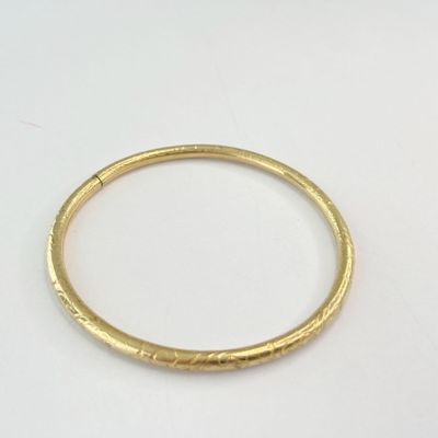 gros plan d'une bague en or sur une surface blanche