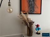 a picture of a table with a vase of flowers and a lamp