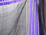 a close up of a purple and black dress with white stripes