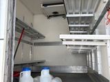 a white truck with two containers of milk in the back