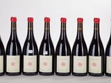 six bottles of red wine lined up in a row