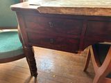 a wooden desk with a marble top and a green chair