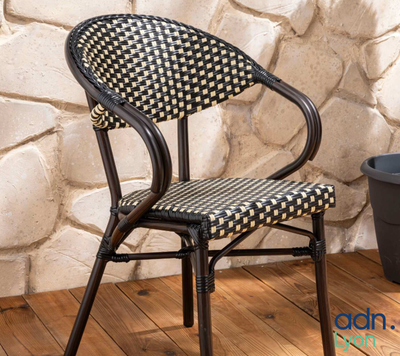 a black and white chair sitting on a wooden floor next to a potted plant