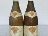 deux bouteilles de vin posées sur une table l'une à côté de l'autre