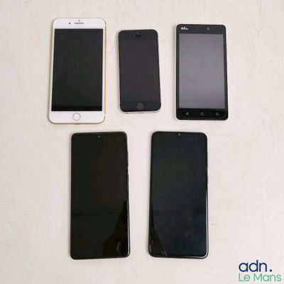 three iphones are sitting next to each other on a table