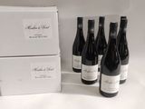 Plusieurs bouteilles de vin sont posées à côté d'une boîte de vin