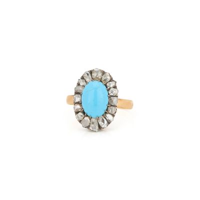 un gros plan d'une bague sertie d'une pierre turquoise sur fond blanc