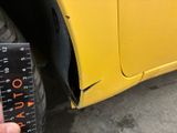 someone is measuring the height of the tire on a yellow truck