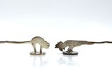 three figurines of animals that are on a white surface
