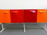 un buffet orange et rouge posé sur un piètement en métal